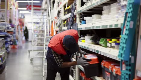 Male-supervisor-arrange-goods-on-shelves-of-hardware-store