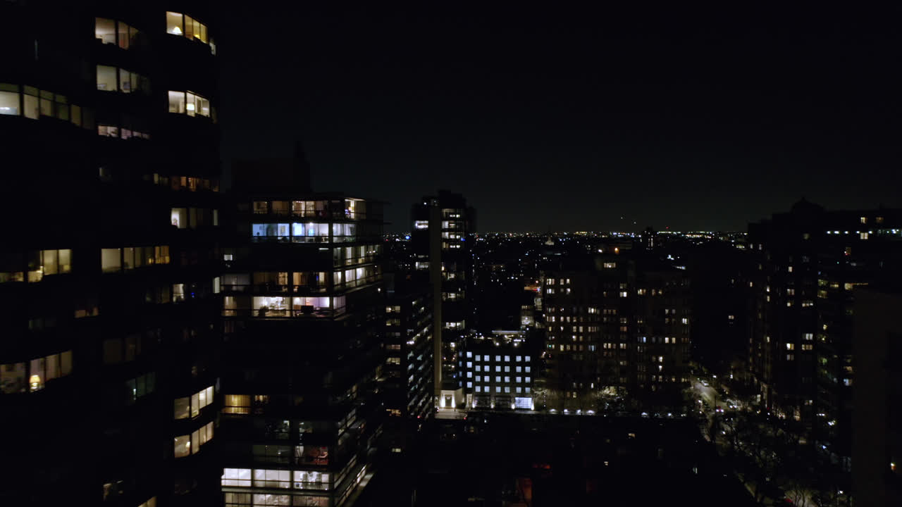 воздушный дрон вперед движущийся снимок высотных офисных и жилых зданий в ночное время в чикаго в сша