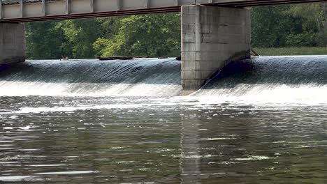 river water rushing under concrete bridge panning shot 4k