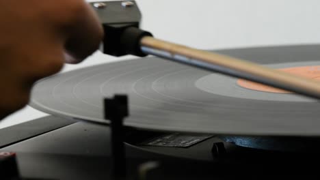 spinning vinyl record being switched off by a woman hand