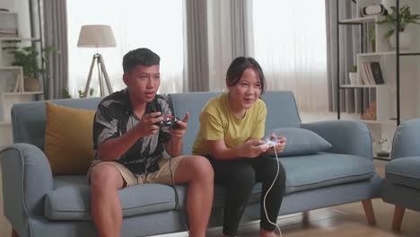 asian children with joystick game play video game on tv, girl celebrating victory and boy disappointed