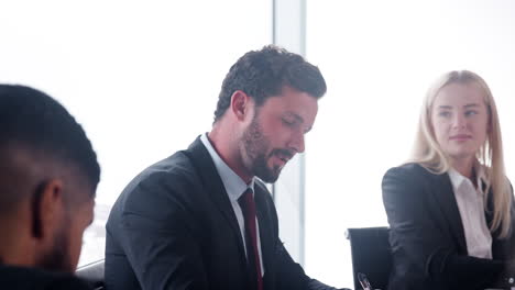 Slow-Motion-Shot-Of-Young-Businessman-Speaking-At-Meeting-Around-Boardroom-Table