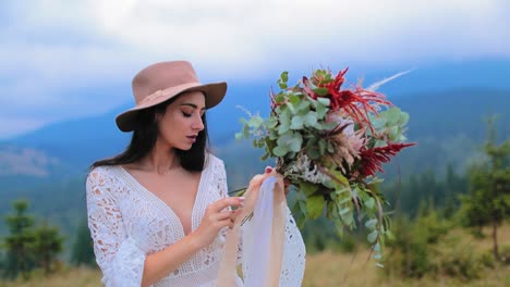 woman posing on top of mountains. pretty long haired girl in wedding dress on mountain meadow