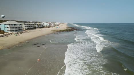 las olas de la playa de kure dan vueltas en la costa, toma aérea ascendente que se extiende hasta el horizonte.