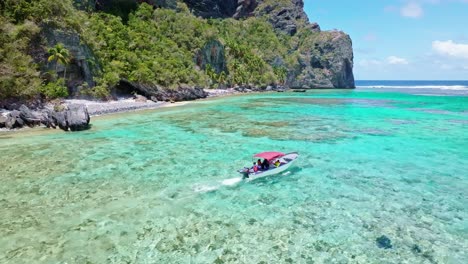aerial view of tourist in boat cruising on crystal clear caribbean sea in front of playa fronton