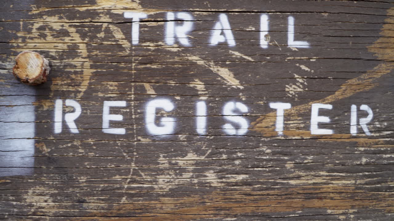 A closeup of a trail register sits at the start of a hiking trail.