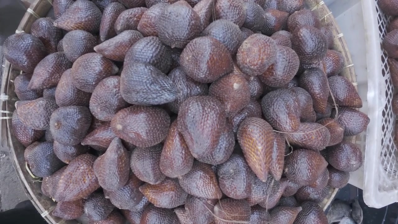 Frutto del serpente Salak fresco in un cesto di vimini al mercato