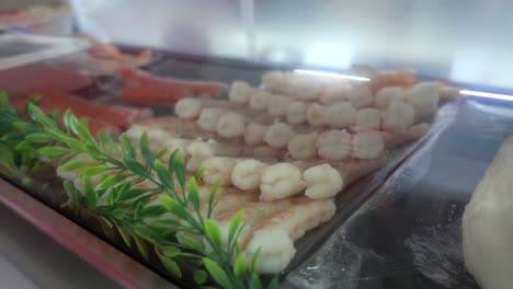 disparo lento que revela filas de camarones recién preparados en un mostrador de restaurante