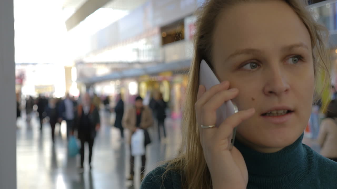 mujer hablando por teléfono en la estación