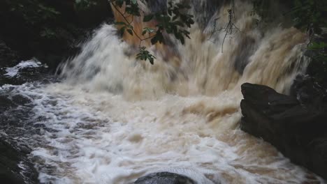 Fast-flowing-peat-coloured-water-in-Welsh-river-after-heavy-rain-storm