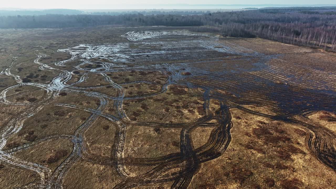 A large meadow has been plowed by a tractor, and the meadow is flooded with water. Europe Lithuania.