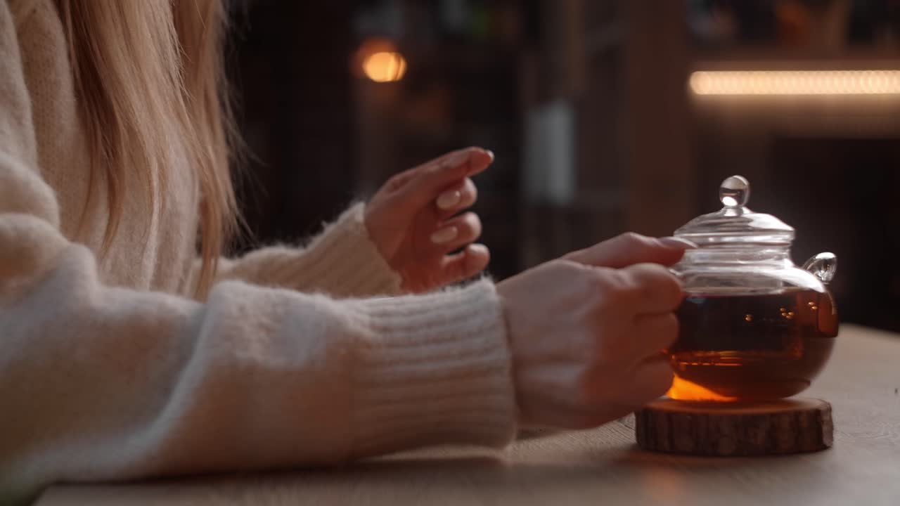 Woman pouring tea in a cozy cafe