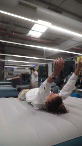 woman relaxing on air mattress in a camping goods store