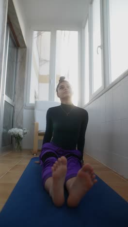 mujer practicando yoga en un balcón