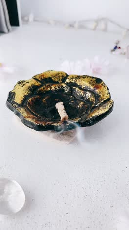 un quemador de incienso en forma de flor dorado y negro