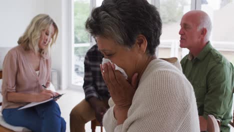 Zwei-Unterschiedliche-Seniorenpaare-Sitzen-Im-Kreis-Und-Führen-Zu-Hause-Ein-Therapiegespräch