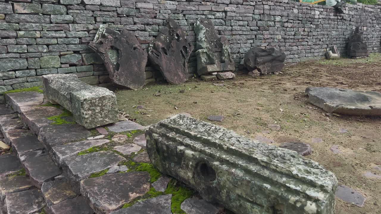 이끼로 덮인 풍화된 블록과 흩어져 있는 유물로 이루어진 고대 석조 유적은 역사적인 건축물, 유산, 고고학적 텍스처를 강조하고 있어요.