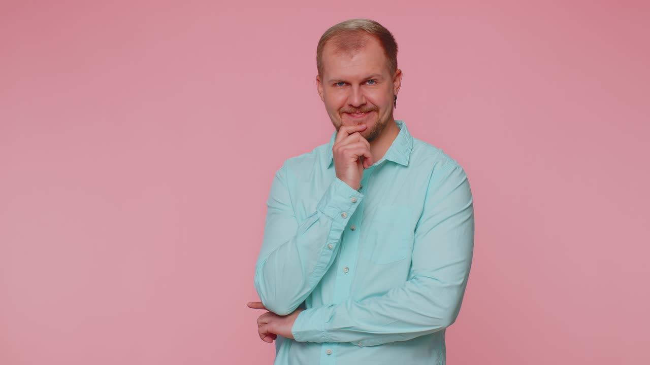 Smiling playful happy man blinking eye looking at camera with toothy smile winking and flirting