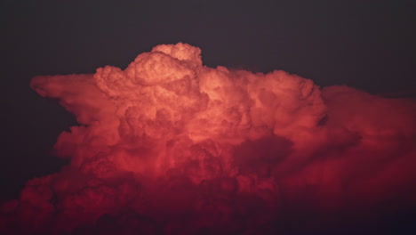 Time-lapse of vibrant, red sunset clouds building on the sunlit evening sky