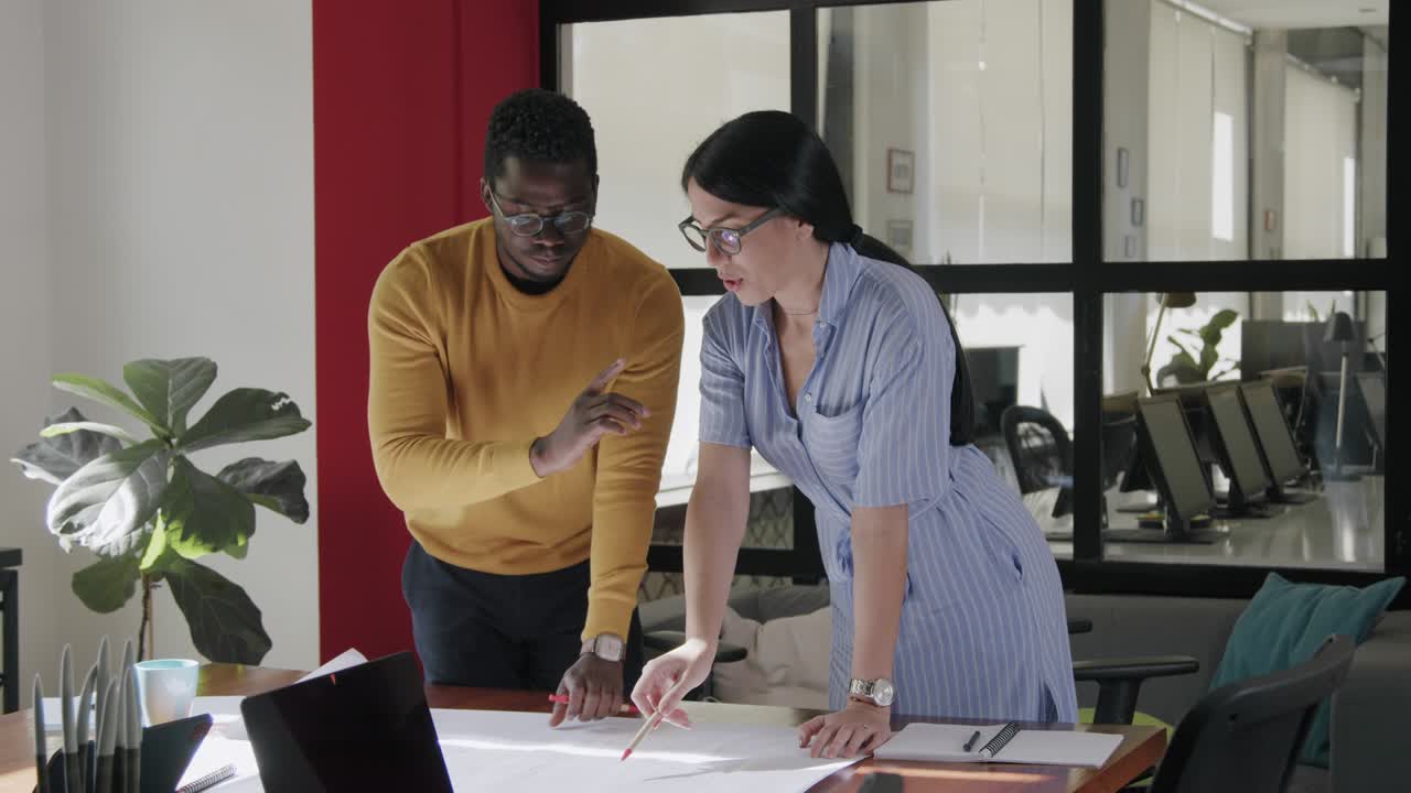 dos compañeros de trabajo haciendo planes en la oficina