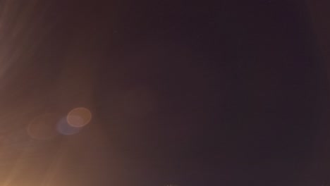 rising moon light ray n star with bokeh lens flare on dark night sky timelapse