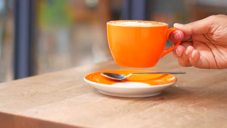 a person holding a cup of latte art coffee