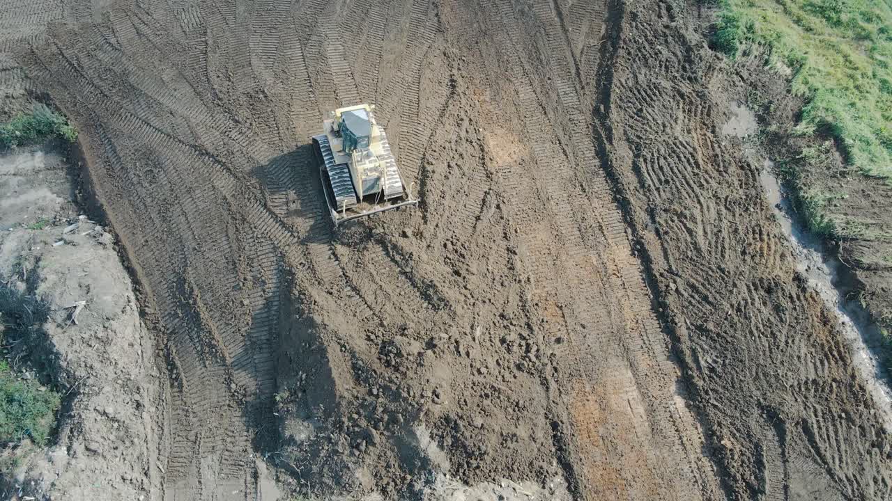 Luftfoto ovenfra af en kraftig gravemaskine, der flytter grus og sten.