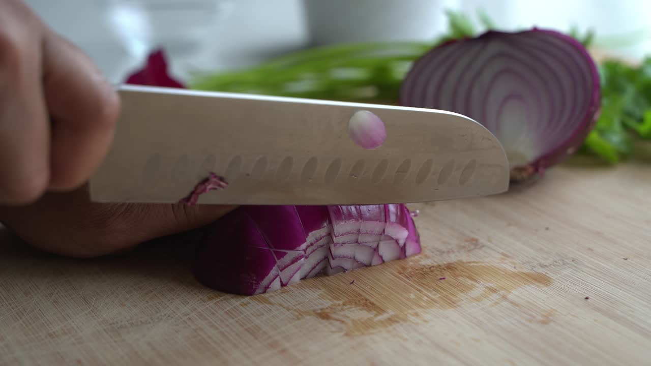 Cutting red onions and special ingredients to cook a meal two cans of beans rice plantain avocado red onion and cilantro