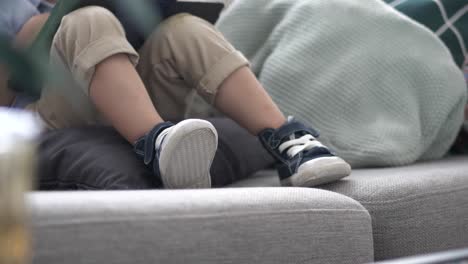 Toddler-wearing-casual-shoes-while-sitting-on-couch
