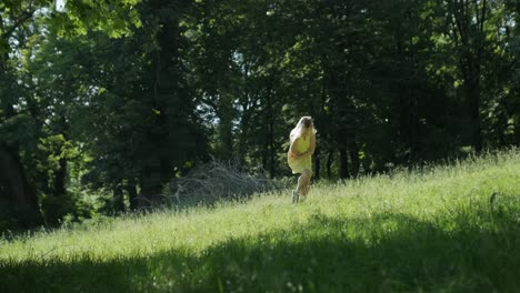 happy beautiful young girl dancing of freedom in summer park with trees in the background.