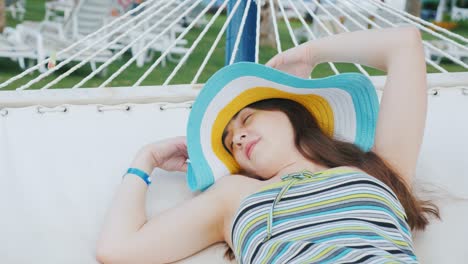 a young sexy lady is resting in a hammock. summer vacation in a luxury resort