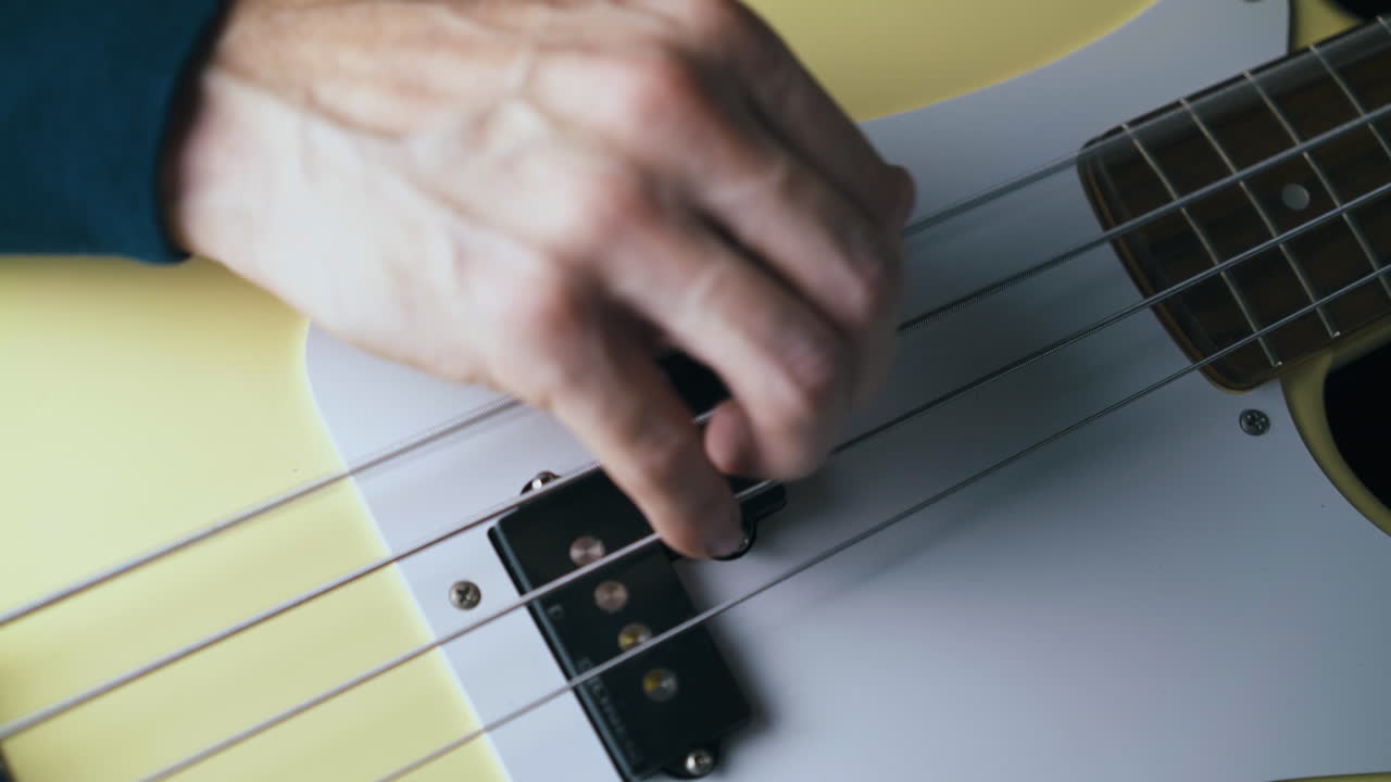 guitarrista profesional toca cuerdas de metal en el bajo