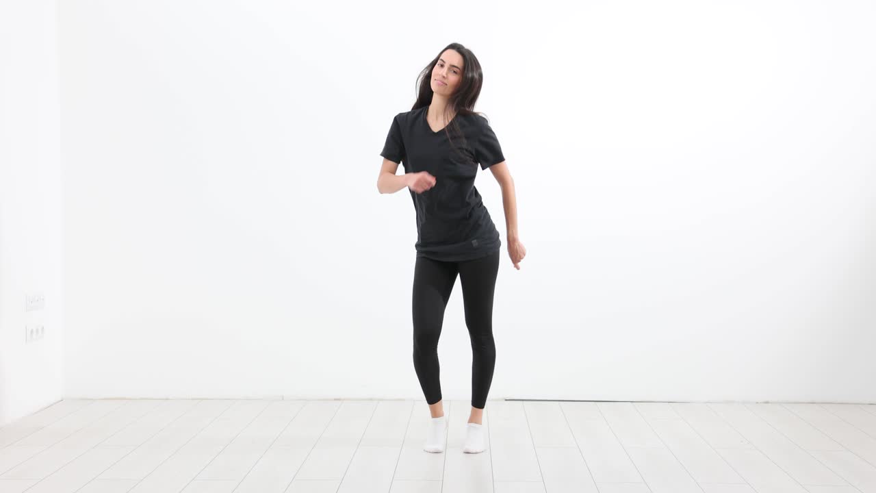 Woman Dancing and Posing in Black Athletic Wear in a White Studio