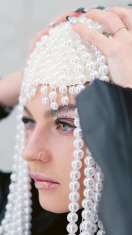 woman with elaborate pearl headpiece and rhinestone eye makeup