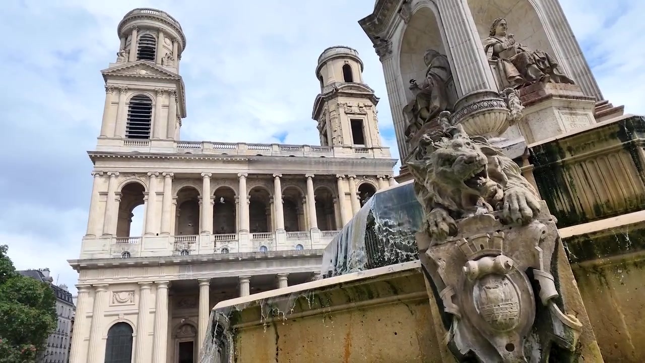 Lavvinkelbillede af en stenløvestatue på et etagefontæne med brusende vand.
