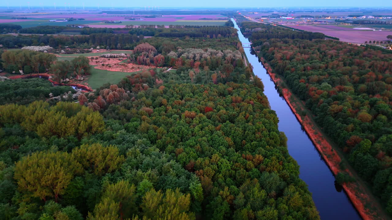 Vibrant Dutch autumn scene. Trees display vibrant fall colors alongside a calm canal in the Netherlands, capturing nature's beauty during autumn