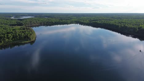 drohnen erschossen über einem großen see im norden wisconsins, umgeben von bäumen.