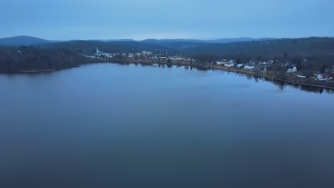 Aerial-footage-approaching-a-small-lake-town-in-america-just-after-sunset