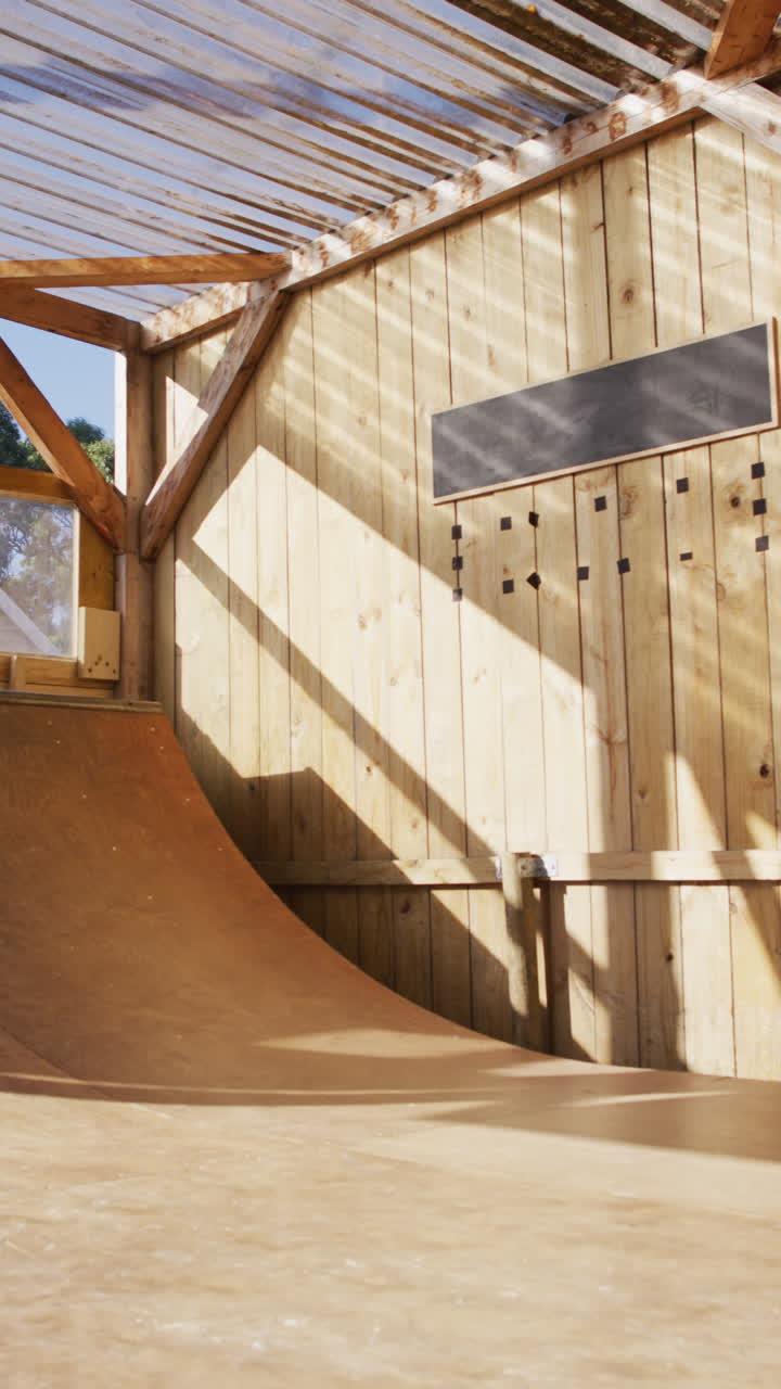 video vertical de un skateboarder caucásico entrenando en un parque de skate