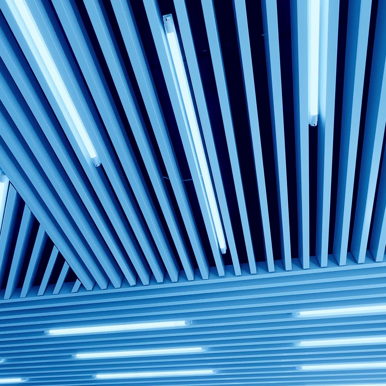 Embossed plank ceiling with bright illumination. Led lamps of day light from low angle perspective