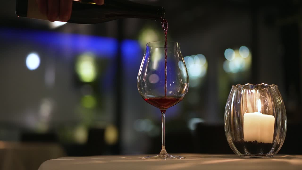 Red wine pouring, slow motion with lots of bokeh while dinner in Italy.