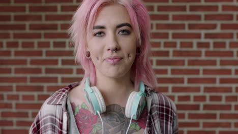 portrait of eccentric young woman pink hair looking alternative smiling happy running hand through hair