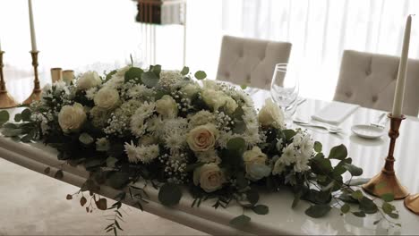 lush white rose and chrysanthemum wedding centerpiece on formal banquet table
