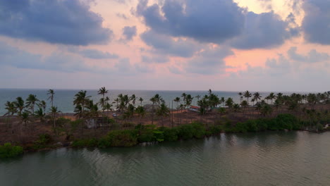 Evening-cloudy-sunset-at-beach-,-Beach-side-sunset-view-from-lake-side-with-palm-trees