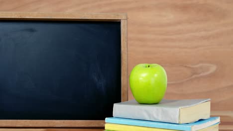 primer plano de libros apilados con manzana verde