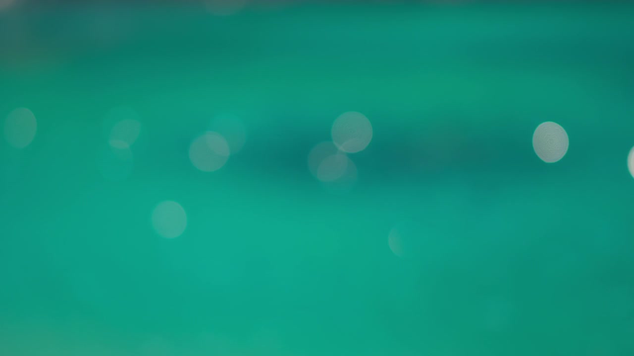 Luce solare bokeh astratta che brilla sulla superficie di un lago turchese.