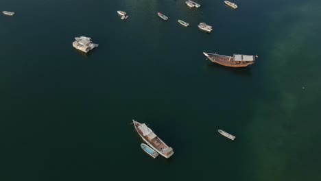 top drone view of the traditional arabian fishing boats moored on the surface of gulf sea, seascape with boats view from above