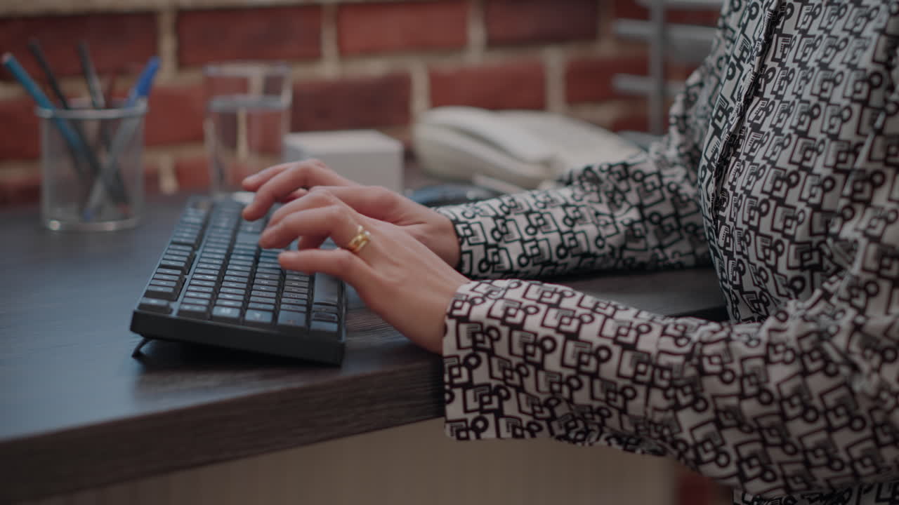 Close up of employee using keyboard to work on computer