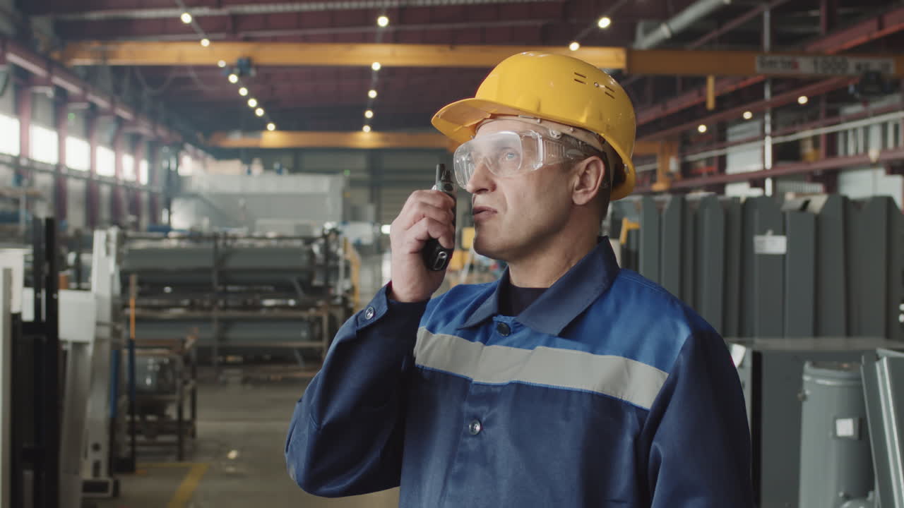 Serious Plant Supervisor Talking Using Walkie-Talkie