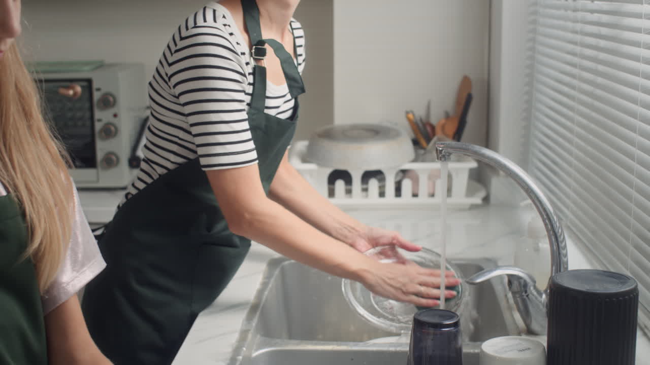 Mother Giving Clean Dishes to Daughter Wiping with Towel